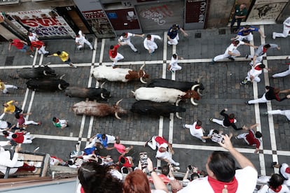 Los mozos son perseguidos por los toros de Miura a su paso por la calle Estafeta.