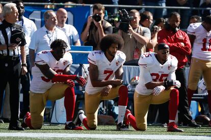 Kaepernick y otros jugadores durante el himno estadounidense