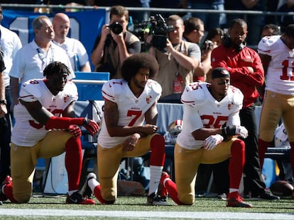 Kaepernick y otros jugadores durante el himno estadounidense