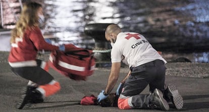 Dos voluntarios de Cruz Roja reaniman a la niña en el muelle de Arguineguín (Gran Canaria).