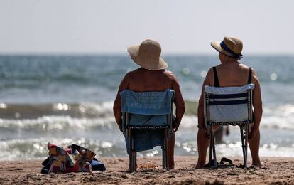 Dos mujeres toman el sol a orillas del mar.