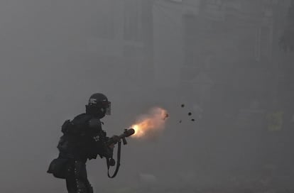 Un oficial de la policía lanza gases lacrimógenos a los manifestantes durante la huelga contra la reforma fiscal en Cali.