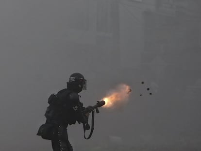 Un oficial de la policía lanza gases lacrimógenos a los manifestantes durante la huelga contra la reforma fiscal en Cali.