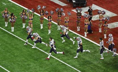 Jugadores de los New England Patriots entran al campo aclamados por las cheerleaders.
