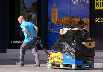 Un trabajador arrastra un palé cargado en Sevilla.