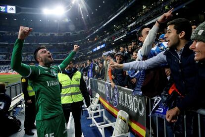 El defensa del Leganés, Diego Rico (i), celebra con los aficionados pepineros su pase a las semifinales de la Copa del Rey tras derrotar al Real Madrid en el encuentro que han disputado esta noche en el estadio Santiago Bernabéu, en Madrid. 