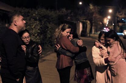 Unos vecinos se abrazan en las calles de Santiago tras el terremoto.