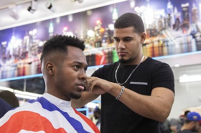 Un empleado de la barbería New York realiza un corte 'undercut', despejado en la nuca y laterales en un degradado.