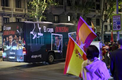 Los manifestantes ondean banderas de España mientras un autobús con imágenes de Pedro Sánchez pasa al frente de la protesta. Jaime Villanueva/El País