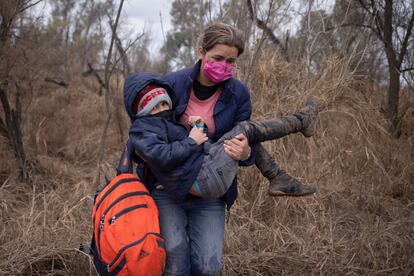 Gabriella, una migrante hondureña carga a su hijo de seis años mientras caminan rumbo a EE UU.