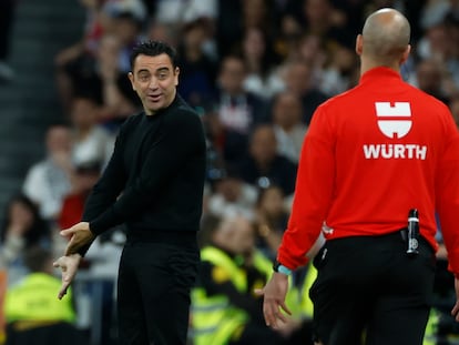 Xavi Hernández conversa con el cuarto árbitro en el clásico en el Santiago Bernabéu.