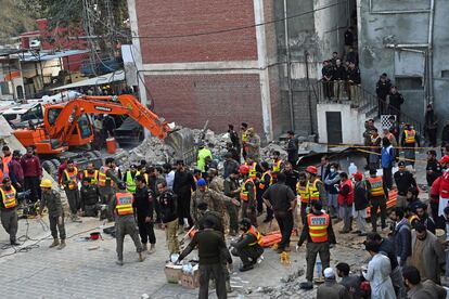 Bomberos y voluntarios inician el rescate de los atrapados bajo los escombros de la mezquita paquistaní de Peshawar, tras la explosión de este lunes.