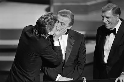 Michael Douglas besa a su padre Kirk Douglas junto a Burt Lancaster en los Oscar de 1985.