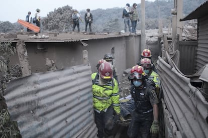 Un grupo de bomberos transporta a una víctima en la zona de Escuintla (Guatemala).