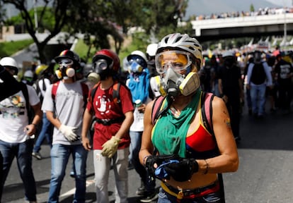 Un grupo partidarios de la oposición se enfrentan contra policías antidisturbios.