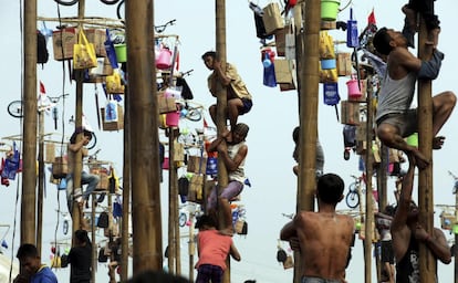 Varios ciudadanos intentan trepar a lo alto de postes para alcanzar los regalos colgados en lo alto durante las celebraciones por el 72º Día de la Independencia en Yakarta (Indonesia).