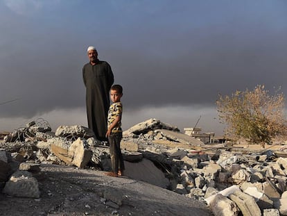 Salih Latif e um de seus filhos na montanha de escombros que restou de seu lar em Haji Ali.