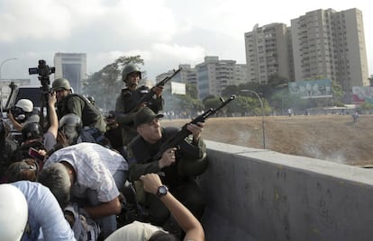 Tropas alzadas contra el Gobierno de Nicolás Maduro disparan sus armas desde un paso elevado fuera de la base aérea militar La Carlota, en Caracas.
