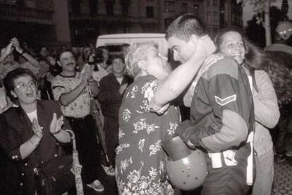 A woman embraces one of the <i> ertzainas</i> outside the headquarters of Herri Batasuna in 1997.
