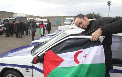 Un hombre coloca una bandera saharaui en uno de los coches donados por la Ertzaintza.