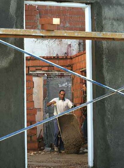 Un vecino trabaja en el interior de la vivienda en obras de Abdul, en la Cañada Real.