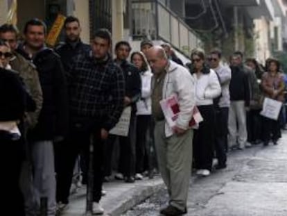 Desemplados hacen cola en una oficina del Servicio Nacional de Empleo para recoger cheques de ayuda, en Atenas (Grecia). EFE/Archivo