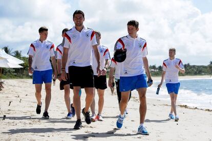 Atletas da Alemanha caminham por praia da Bahia.