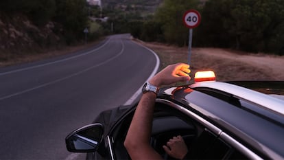 Una persona colocando la Baliza V16 en el techo de su coche.