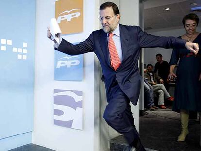 El líder del PP, Mariano Rajoy, tropieza justo antes de dirigirse a los medios de comunicación, en la sede del PP en Madrid.