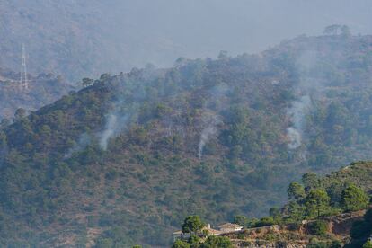 El humo y los rescoldos permanecen en el aire tras el incendio en Pujerra (Málaga).