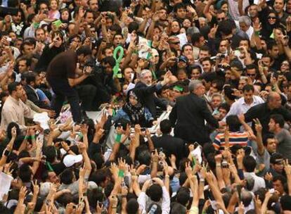 El candidato reformista derrotado, Mir Hosein Musaví (centro), saluda a sus seguidores durante la multitudinaria marcha celebrada en la capital iraní.