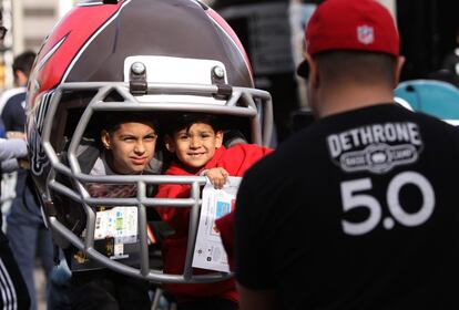 Unos niños posan junto a un casco gigante de fútbol americano en la calle Market en San Francisco, el 4 de febrero de 2016.