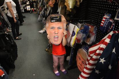 Una niña de cuatro años posa para la foto con una careta de Donald Trump en un centro comercial, el 26 de octubre, en Florida (EE UU).