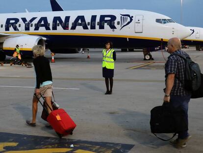 Pasajeros de Ryanair, a pie de pista y con equipaje de mano, durante un embarque en el aeropuerto de Londres-Stansted. 