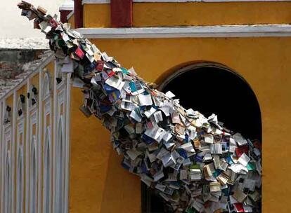 Esculturas alegóricas a la literatura, como este cono de libros que sale por una ventana de una casa del centro histórico de Cartagena de Indias, pueden verse por toda la ciudad para ambientar el Congreso de la Lengua Española.