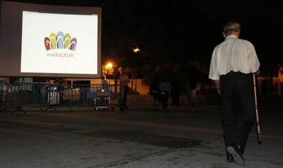 Un anciano ante la pantalla gigante instalada en el parque de Canillejas. 