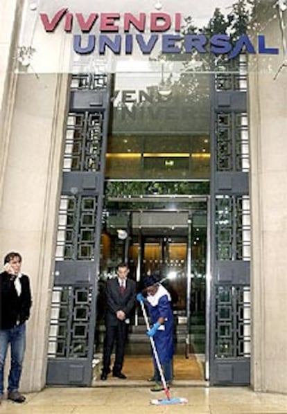 Un empleado limpia la entrada de las oficinas centrales de Vivendi Universal en París.