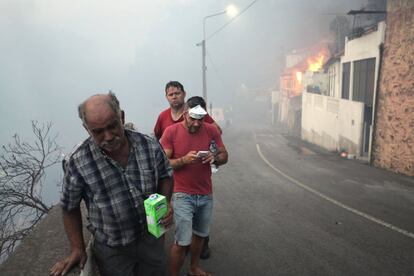 Pessoas na rua enquanto o incêndio se aproxima das casas em Bom Sucesso, ilha da Madeira.