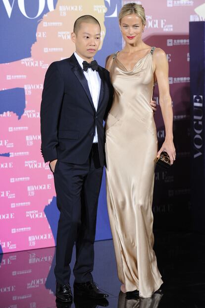 Carolyn Murphy posa junto al diseñador Jason Wu, vestida con un traje de raso creado por éste.