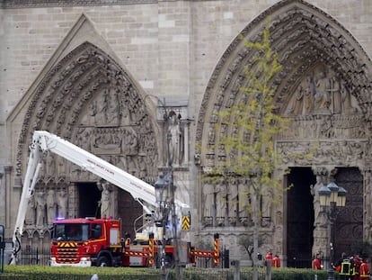 Grupos de bomberos trabajan ante la fachada de la catedral de Notre Dame, esta mañana.