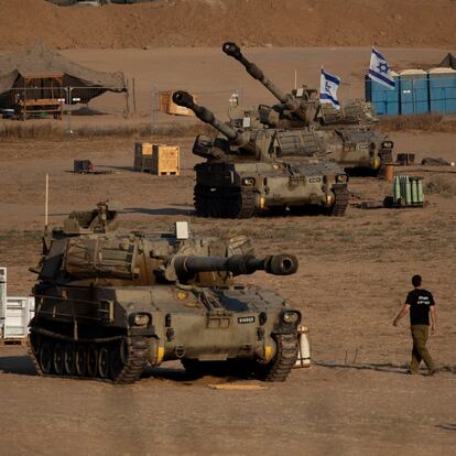 SOUTHERN ISRAEL, ISRAEL - AUGUST 7: Israeli soldiers walk by artillery units near the border with the Gaza Strip on August 7, 2024 in Southern Israel, Israel. Ten months has passed since the Oct. 7th Hamas-led attack on southern Israel, which sparked a devastating war in Gaza that threatens to spill into the wider region. (Photo by Amir Levy/Getty Images)