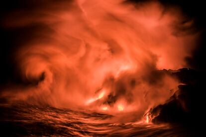 En eta imagen de agosto de 2017, los gases producidos por contacto de la lava y el agua salada se arremolinan jugando con el viento que entra desde el Pacífico en la isla de Hawái.