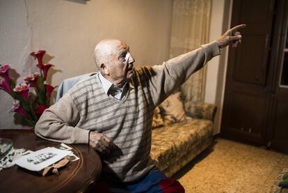 Ignacio Espasa assenyala el cel des del menjador de casa seva a Alfés. Sobre la taula, unes fotografies de quan ell jugava a l'equip del poble a la dècada de 1950. A la falda, les primeres mitgetes que va utilitzar, color blaugrana.