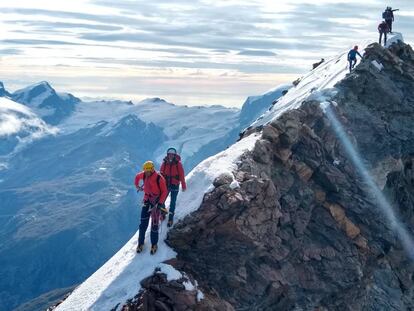 El guía argentino Tomi Aguiló y su clienta Elisa recorren el camino entre la cima suiza y la italiana.