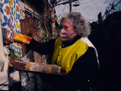 Una voluntaria de Hogar de Cristo entrega alimentos de primera necesidad en un barrio popular argentino.