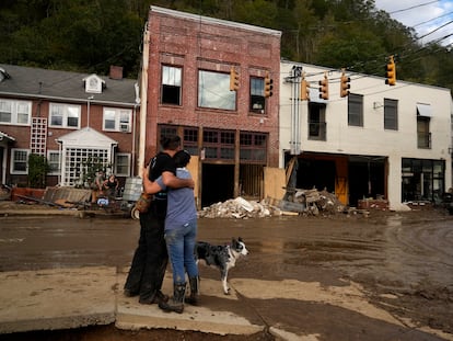 La residente Anne Schneider, derecha, abraza a su amigo Eddy Sampson mientras examinan los daños causados por el huracán Helene, el martes 1 de octubre de 2024, en Marshall, Carolina del Norte.