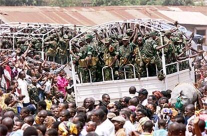 Soldados ruandeses saludan a una multitud mientras abandonan la República Democrática de Congo.