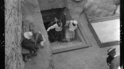 Carter y un trabajador egipcio sacan un trozo de un lecho de la tumba de Tutankamón, en febrero de 1923 mientras los retrata otro miembro del equipo, probablemente Lord Carnarvon.