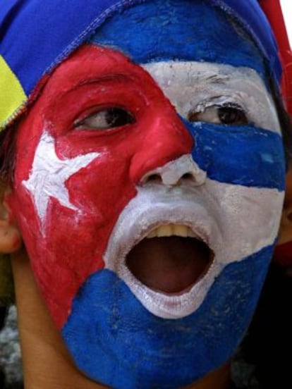 Uma mulher com a bandeira cubana pintada no rosto em frente à embaixada de Cuba na Venezuela.