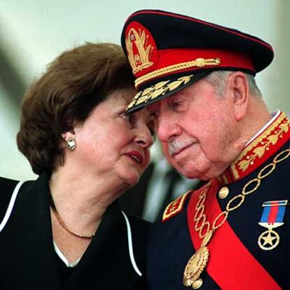 Foto de archivo de Augusto Pinochet conversando con su esposa Lucía Hiriart durante la ceremonia de entrega de mando del ejército chileno, el 10 de marzo de 1998.